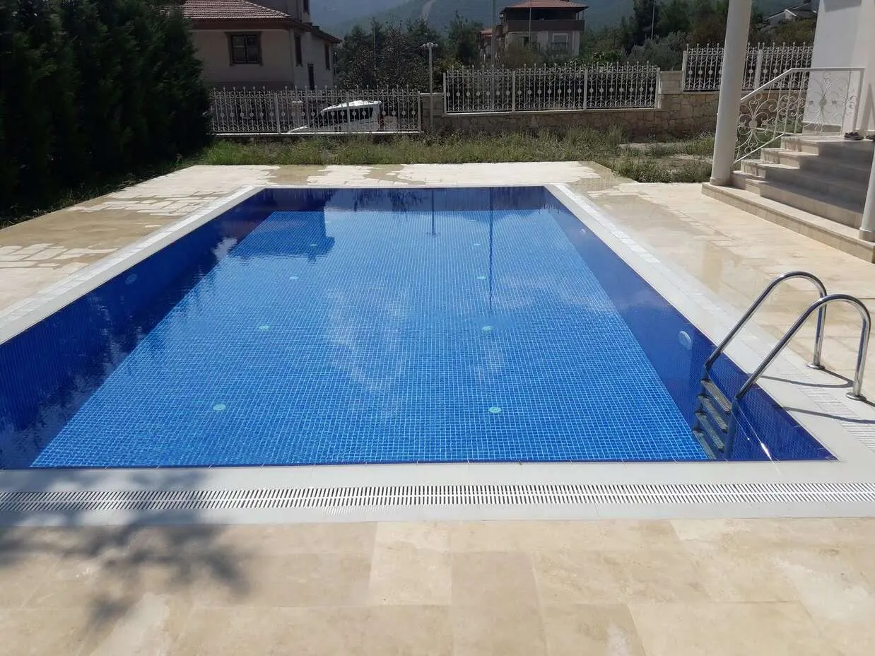 Havuzda serinlemenin keyfini çıkarın. Safir mavisi suyu ve huzur veren atmosferiyle göz alıcı bir yüzme havuzu.